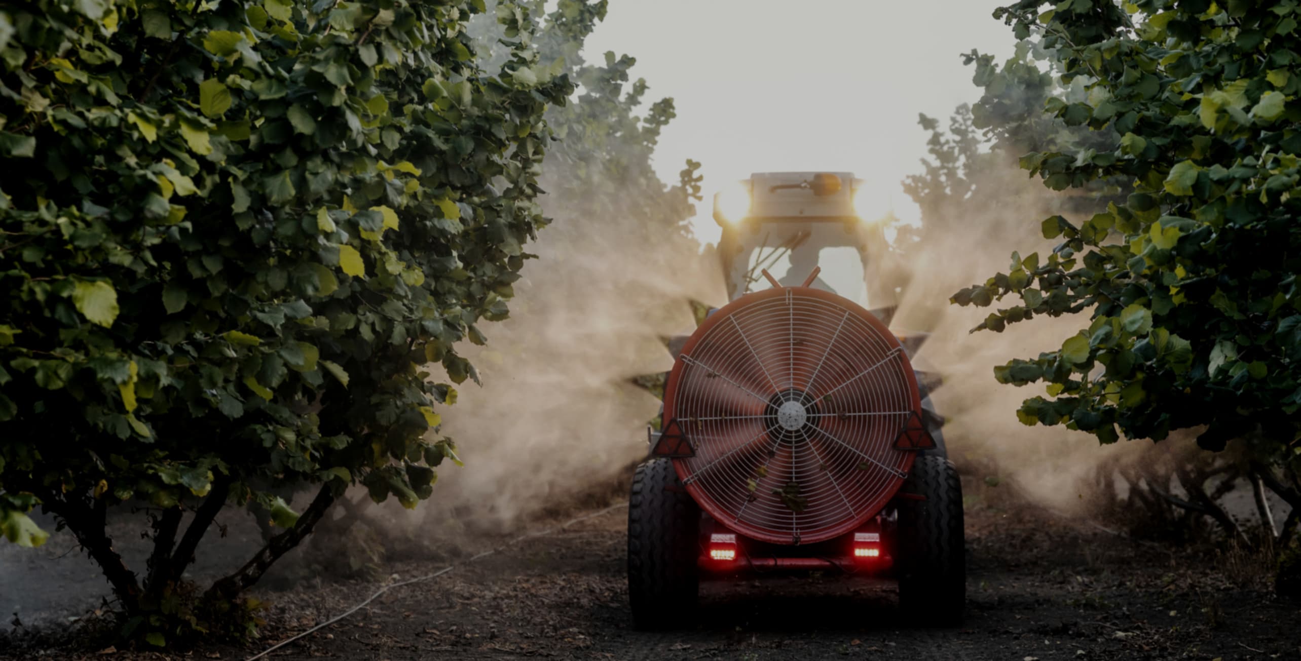 Tractor spraying rows in a specialty crop orchard, tracked by IntelliCulture